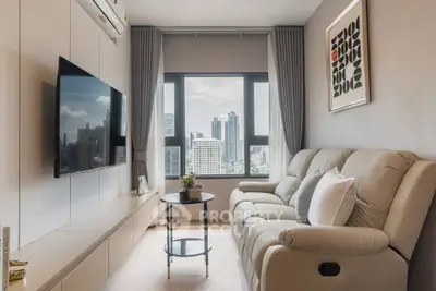 Modern living room with city view, stylish decor, and comfortable seating in a high-rise apartment.