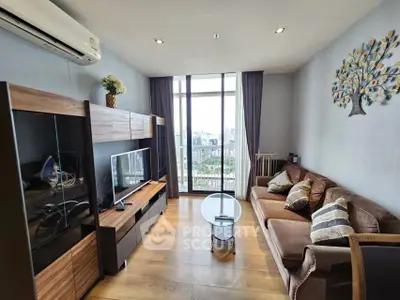 Stylish living room with modern decor and city view, featuring a cozy sofa and entertainment unit.