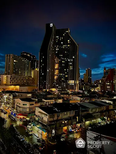 Stunning cityscape view with modern high-rise building at night, showcasing vibrant urban living.