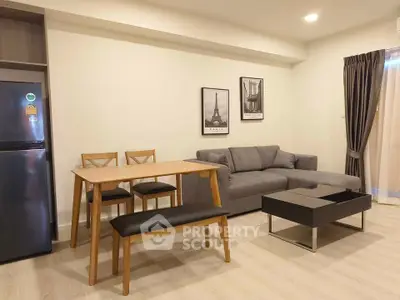 Modern living room with stylish furniture and wall art, featuring a cozy gray sofa and wooden dining set.
