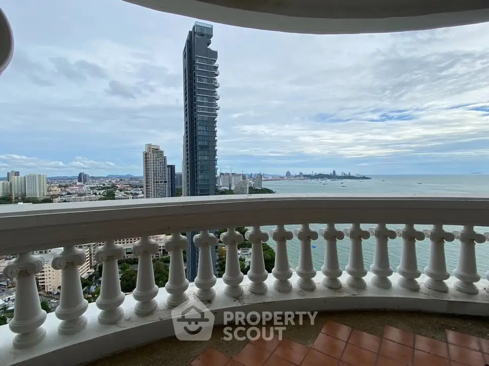 Stunning high-rise balcony view of city skyline and ocean, perfect for luxury living.