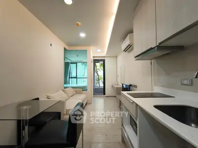 Modern open-layout living room with sleek kitchen and cozy seating area