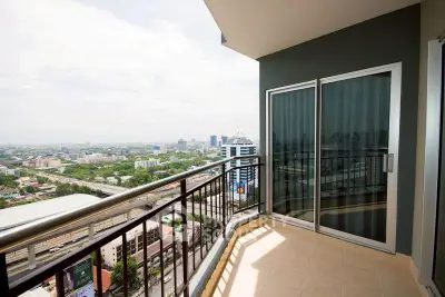 Stunning high-rise balcony with panoramic city views and modern glass doors.