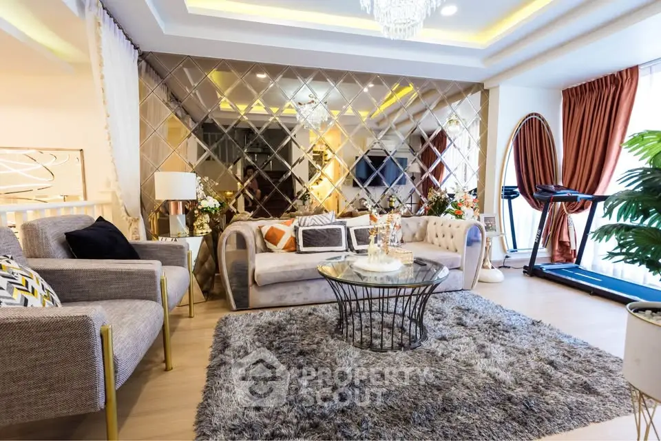 Luxurious living room with plush seating, elegant decor, and a home gym setup.