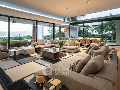 Luxurious open-plan living room with stunning garden view and modern decor.
