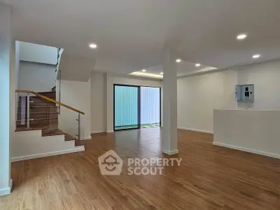 Spacious modern living room with wooden flooring and large windows