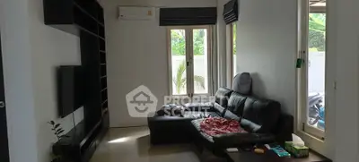Cozy living room with black leather sofa and modern entertainment unit