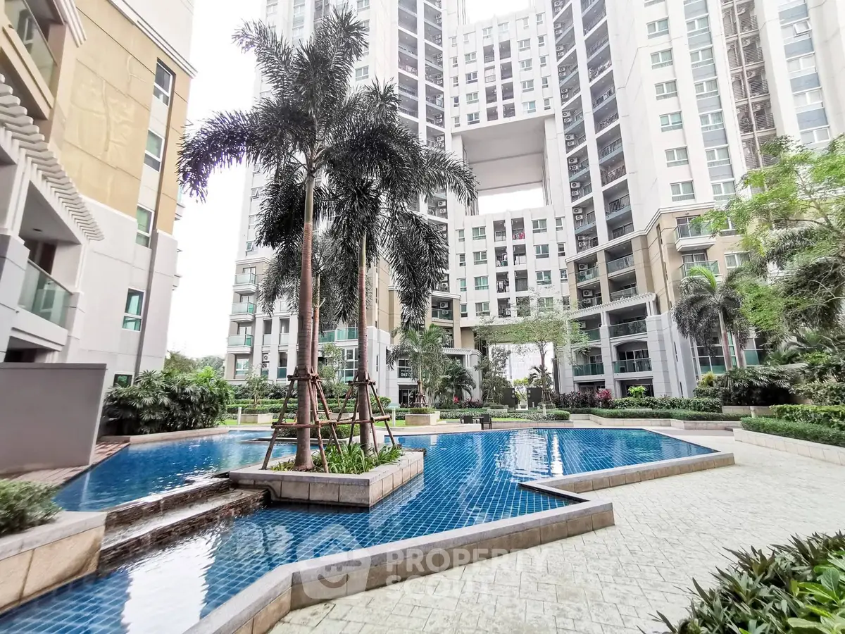Luxurious apartment complex with stunning pool and lush greenery, perfect for modern living.