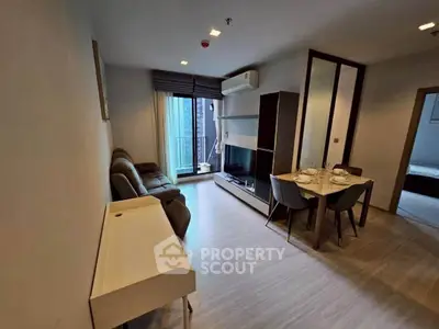 Modern living room with dining area and balcony access in a stylish apartment.