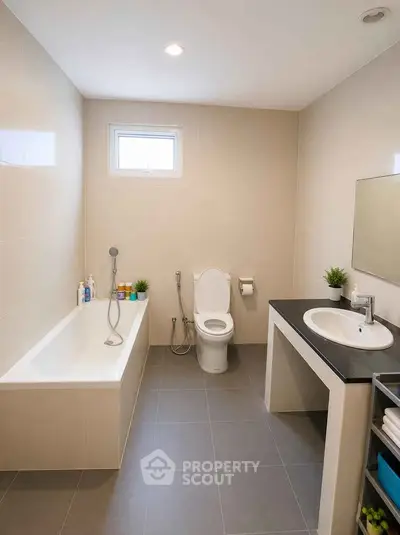 Modern bathroom with sleek design, featuring a bathtub and contemporary fixtures.