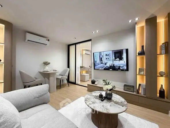 Modern living room with stylish decor and open layout, featuring a wall-mounted TV and elegant furniture.