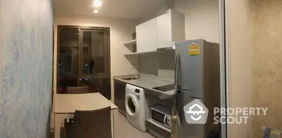 Modern compact kitchen with washing machine and fridge in urban apartment