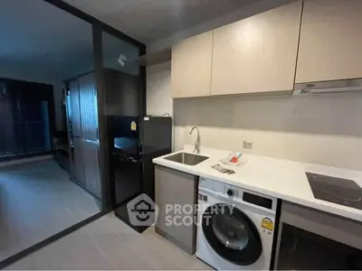 Modern kitchen with washing machine and sleek cabinetry in a stylish apartment