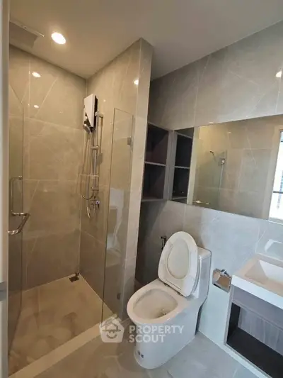 Modern bathroom with sleek shower and elegant fixtures in contemporary apartment.