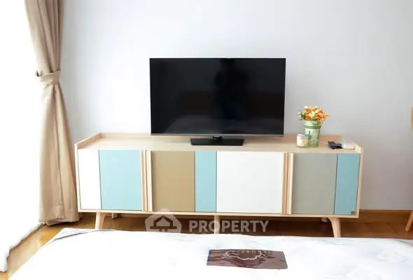 Modern living room with stylish TV stand and flat-screen TV, bright and inviting space.