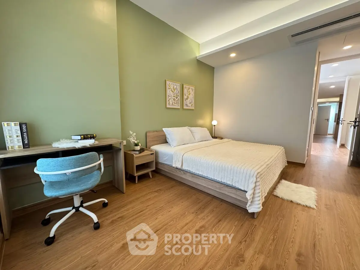 Modern bedroom with study area, wooden flooring, and stylish decor