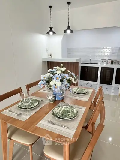Elegant dining area with wooden table set and modern kitchen in open layout