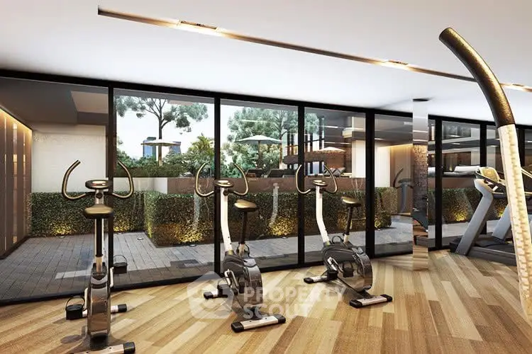 Modern gym with exercise bikes and large windows overlooking garden
