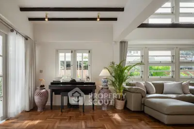 Elegant living room with parquet flooring, large windows, and stylish decor