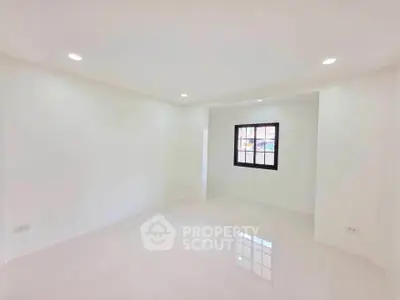 Spacious and bright empty room with glossy white tiles and recessed lighting, perfect for customization.