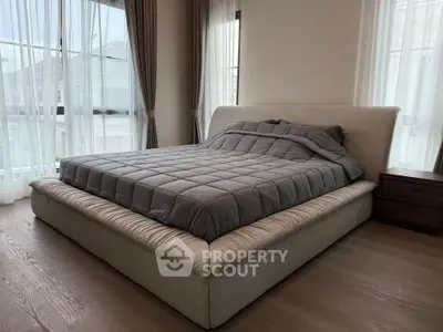 Luxurious bedroom with plush bed and large windows for natural light