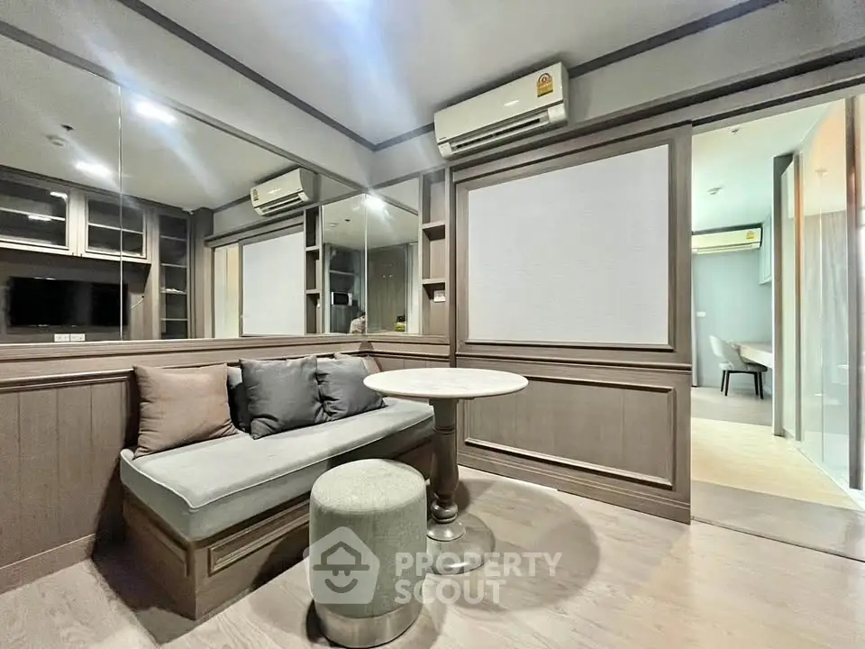 Modern living room with stylish wood paneling and cozy seating area, featuring air conditioning and elegant decor.