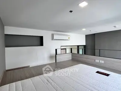 Modern loft bedroom with sleek design and air conditioning unit.