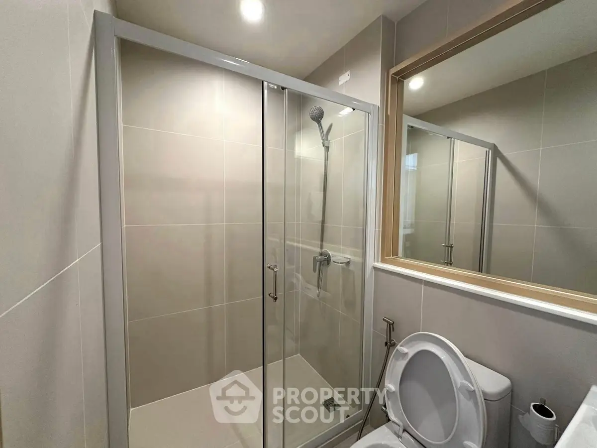 Modern bathroom with glass shower enclosure and sleek fixtures