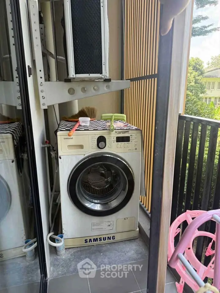 Compact balcony with Samsung washing machine and outdoor view, ideal for urban living.
