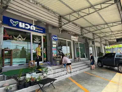 Commercial property exterior with parking area and glass storefronts.