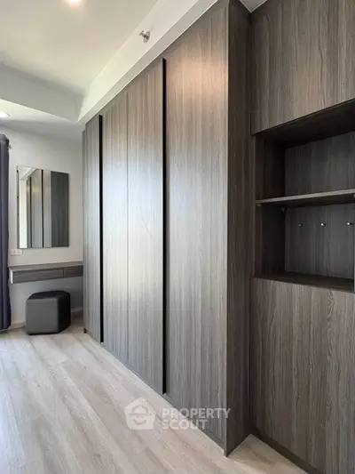 Modern bedroom with sleek wooden wardrobe and stylish vanity area