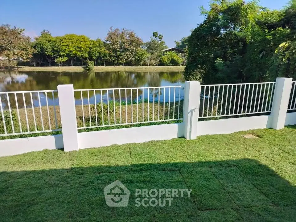 Serene backyard with lush lawn and picturesque lake view, perfect for relaxation and outdoor activities.