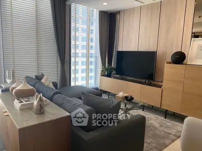 Modern living room with sleek furniture and large windows in urban apartment.