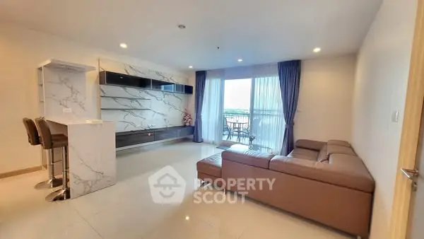 Spacious modern living room with elegant marble accents and large windows offering natural light.