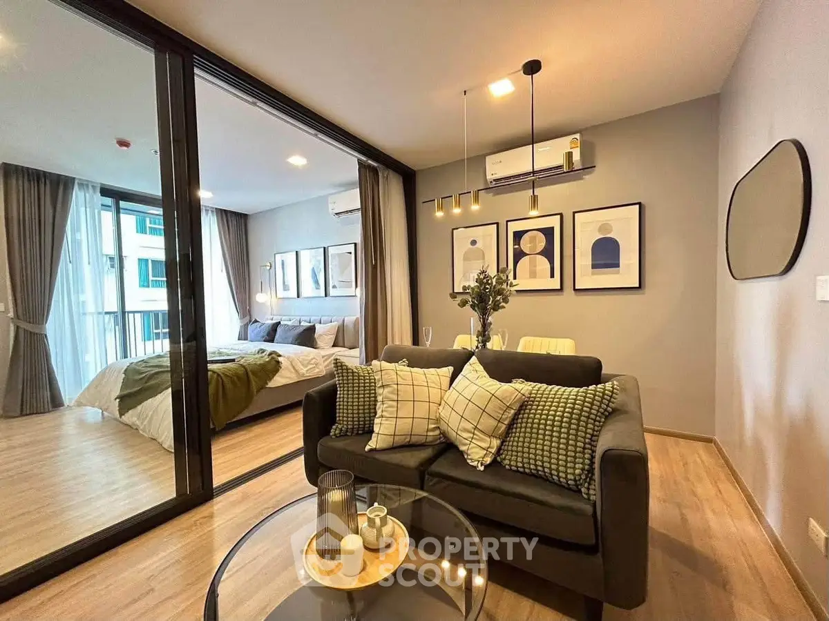 Modern open-plan living room with stylish decor and bedroom view in a chic apartment.