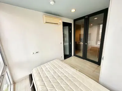 Bright bedroom with large windows and modern air conditioning unit.
