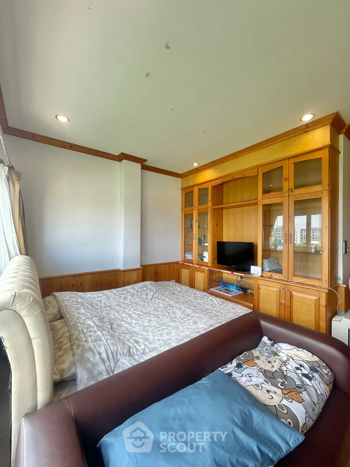 Cozy bedroom with built-in wooden shelves and comfortable seating area