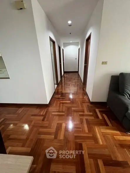 Spacious hallway with polished wooden flooring and modern design.