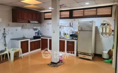 Spacious kitchen with wooden cabinets and modern appliances in a cozy home setting.