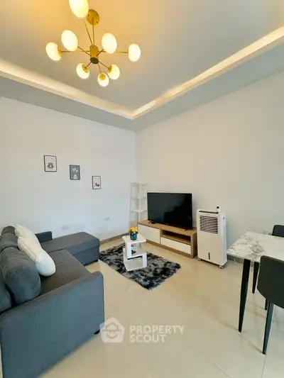 Modern living room with stylish decor, featuring a cozy sofa, chic lighting, and a sleek entertainment setup.
