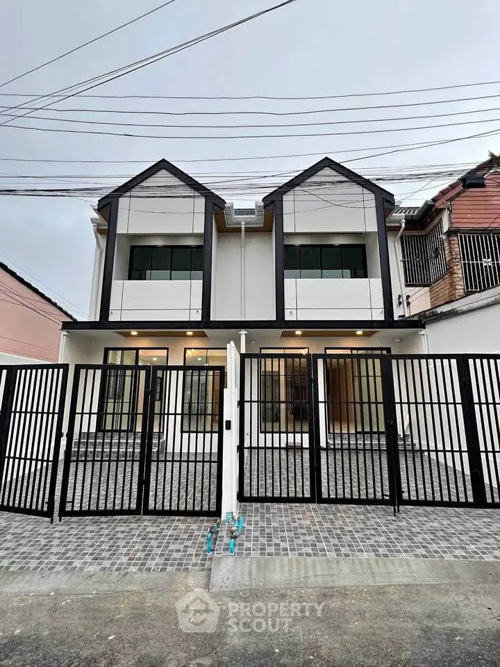 Modern two-story townhouse with gated entrance and contemporary design.