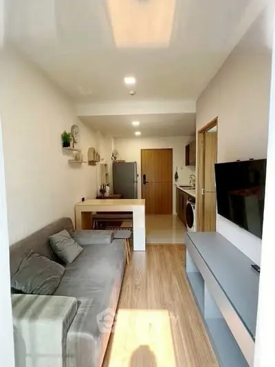 Modern living room with open kitchen, featuring sleek furniture and natural light, perfect for urban living.