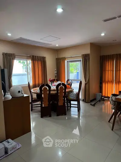 Spacious dining area with natural light and elegant curtains in a modern home.