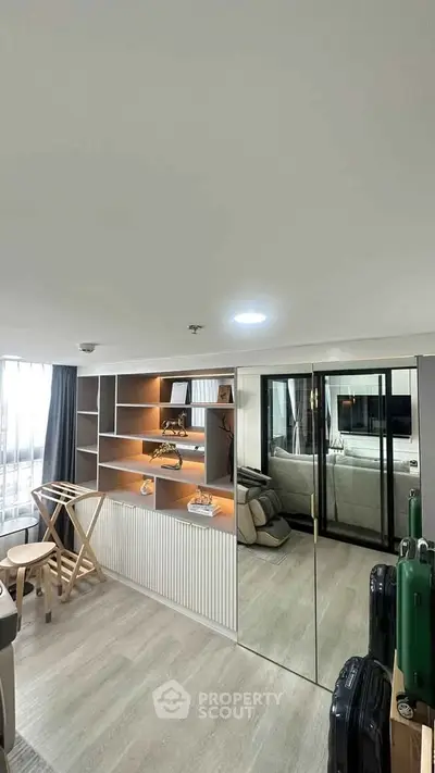 Modern living room with mirrored closet and stylish shelving in a cozy apartment.