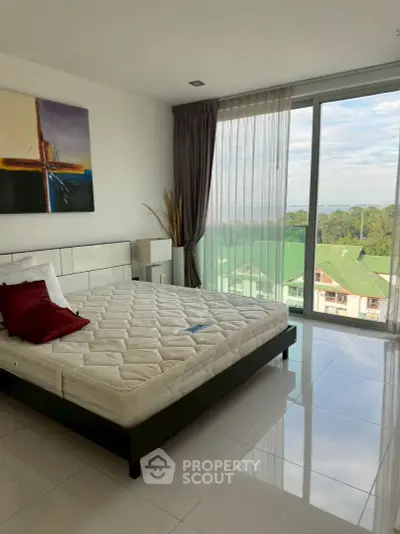 Spacious bedroom with large windows offering stunning views and modern decor.