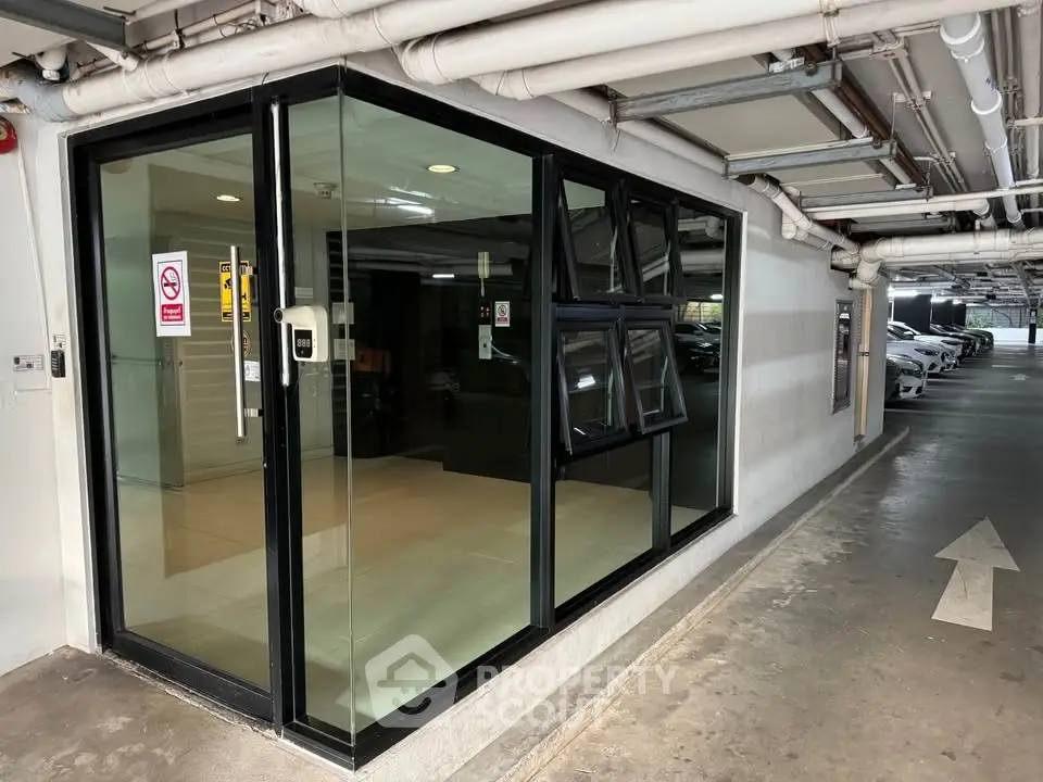 Modern parking area with glass-walled office and directional arrow