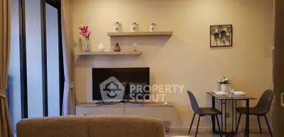 Modern living room with TV, elegant decor, and dining area in a cozy apartment.