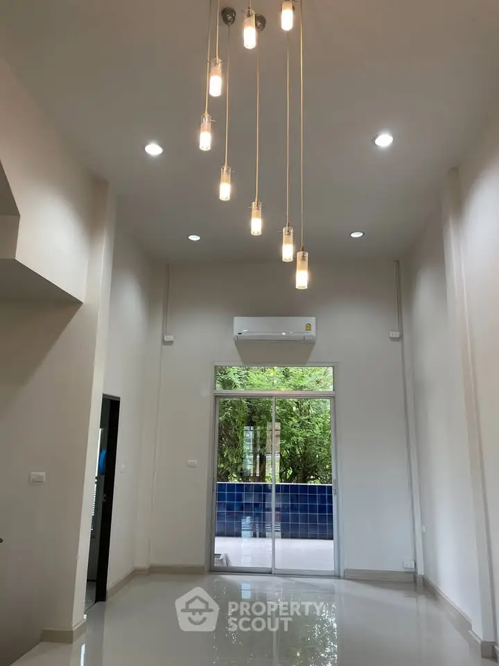 Spacious modern living room with high ceiling and elegant lighting