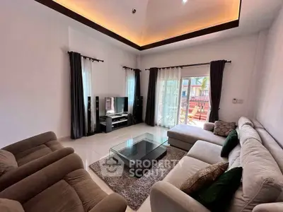 Spacious modern living room with elegant decor and large windows opening to a balcony.