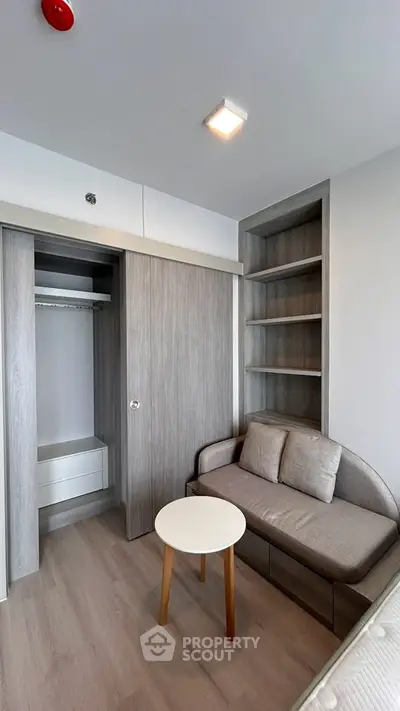 Modern bedroom with built-in closet and cozy seating area, perfect for relaxation.